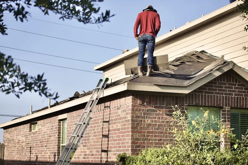 Professional roofer working on a residential roof in Raymond